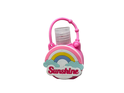 Hand sanitizer in a pink holder with a rainbow and 'Sunshine' text, placed on a stone surface.
