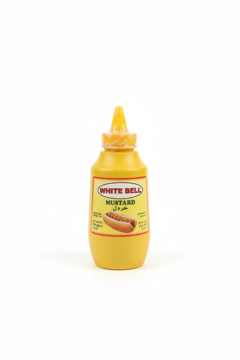 Hand holding a bottle of White Bell Mustard with a blurred background