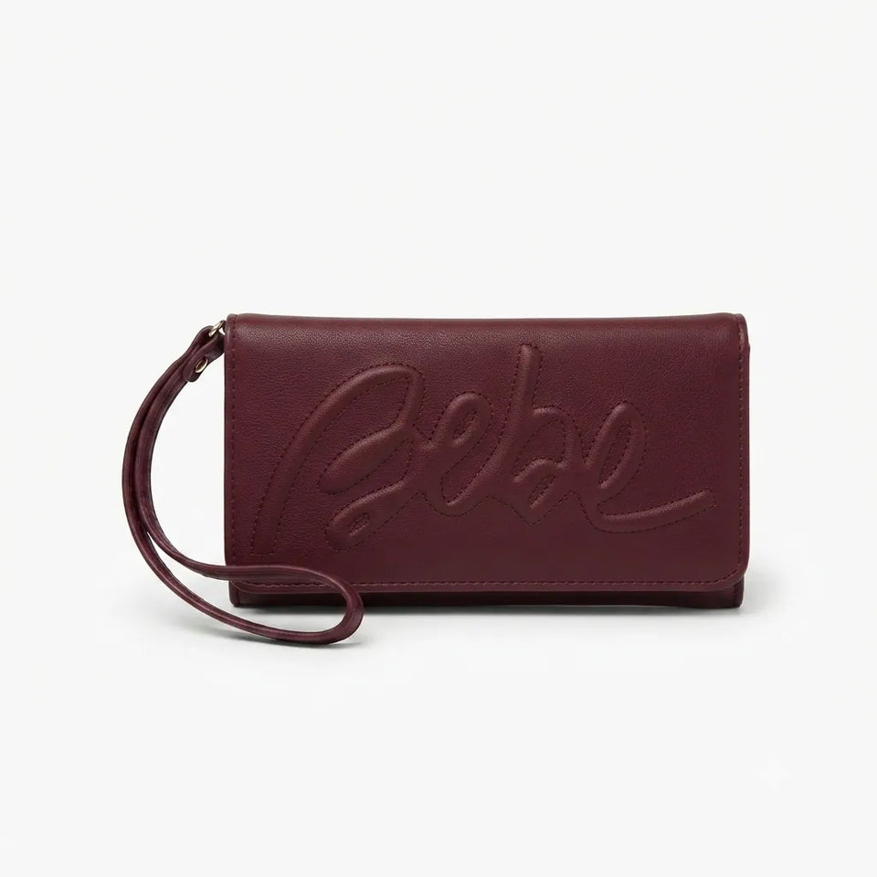 A burgundy leather clutch bag with a matching wristlet strap and an embossed cursive logo on the front, set against a plain white background.