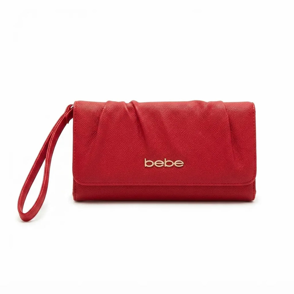 A red textured faux-leather clutch wallet with a wristlet strap and gold 'bebe' logo on the front, shown on a plain white background.