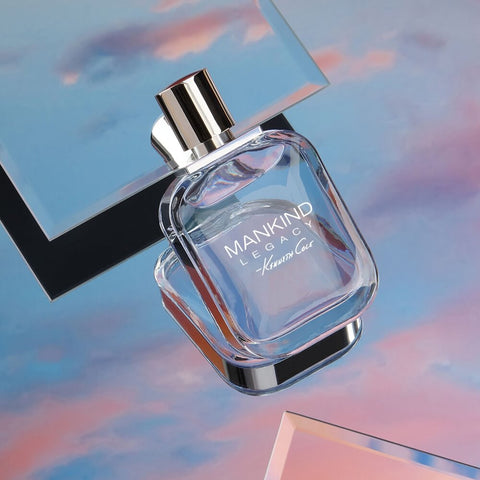 Perfume bottle labeled 'Mankind Legacy' on a reflective surface with a blurred background