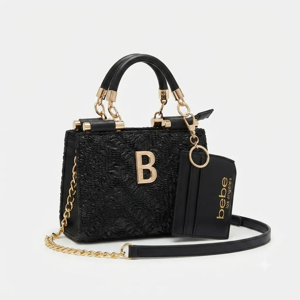 A black textured leather handbag with gold-tone hardware, featuring top handles, a detachable shoulder strap with chain links, a front gold letter B emblem, and a matching black card holder pouch with gold branding.
