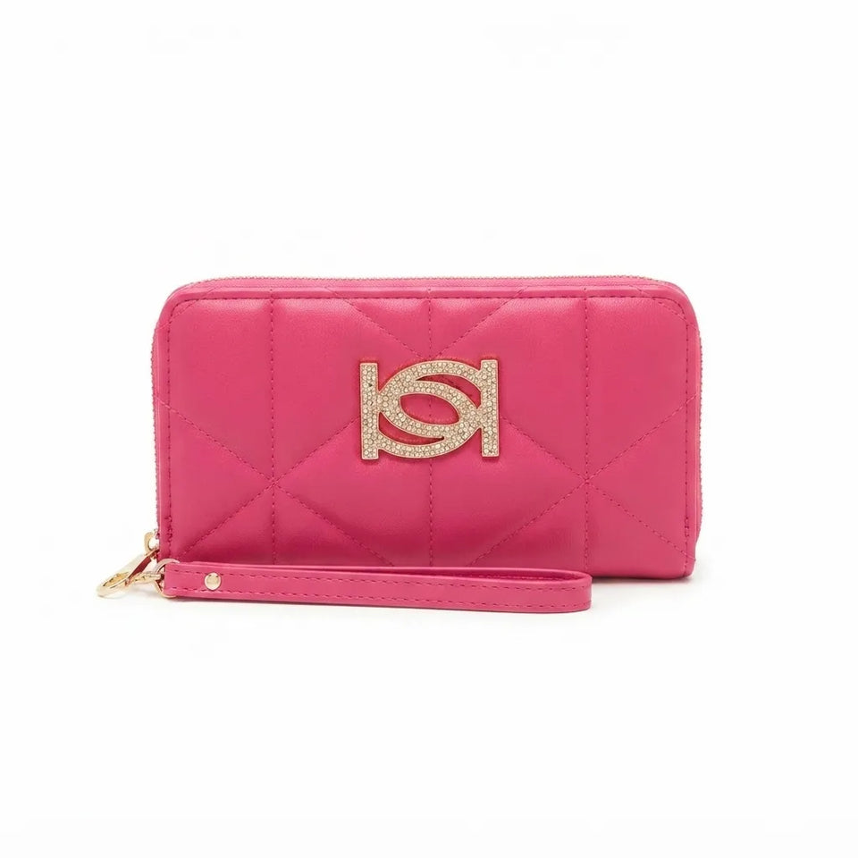 A bright pink quilted zip-around wallet with a matching wristlet strap and a large gold-tone interlocking logo emblem on the front, set against a plain white background.