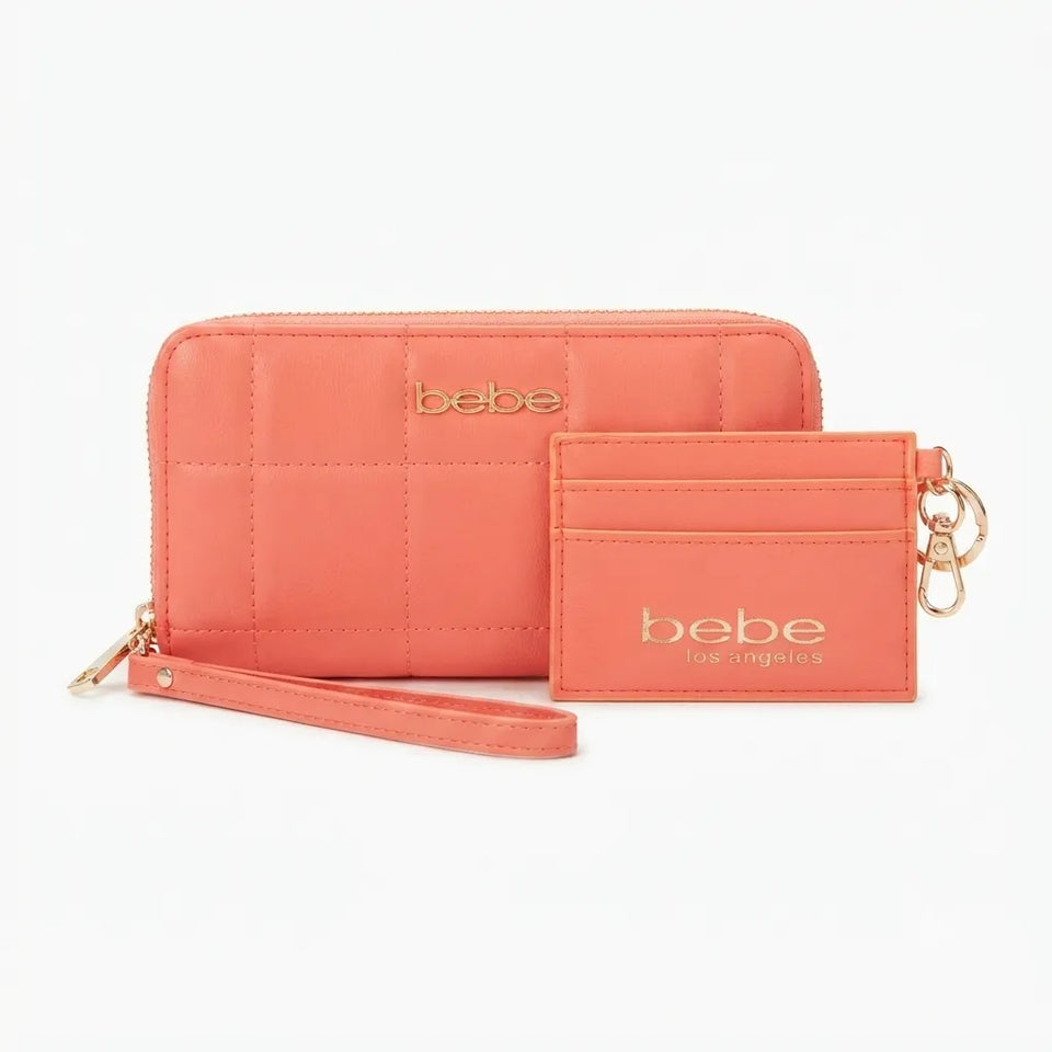 A coral pink quilted wallet and matching card holder set by Bebe Los Angeles, featuring gold-tone logo lettering and keychain rings, set against a plain white background.