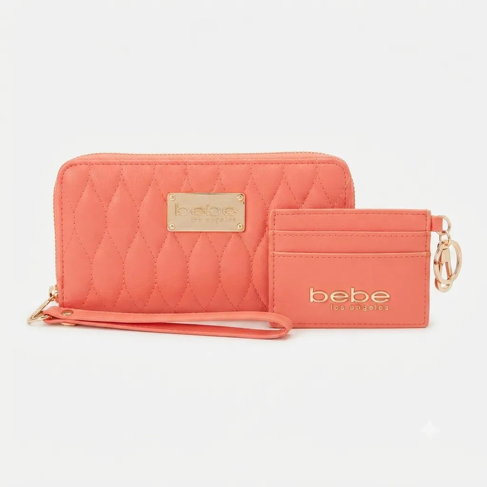 A coral pink quilted wallet and matching wristlet set by Bebe by London, featuring gold-tone hardware and logo details, set against a plain light gray background.