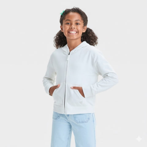 Young girl wearing a light gray hoodie and light blue jeans on a white background