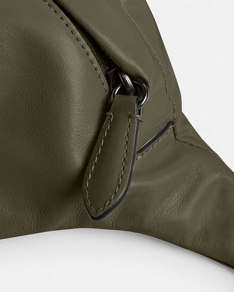 Close-up of a green leather bag with a buckle on a white background