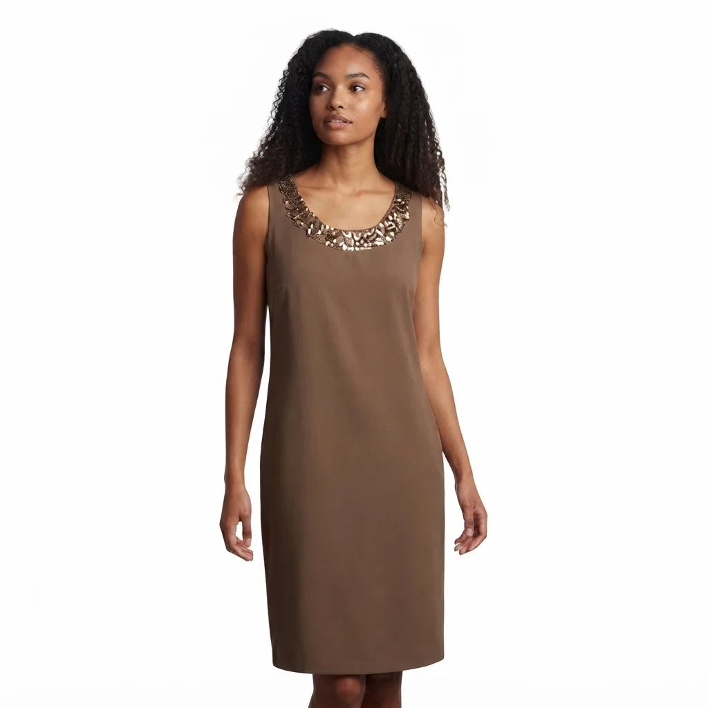 A woman modeling a sleeveless brown shift dress with a decorative beaded neckline, set against a plain white background.