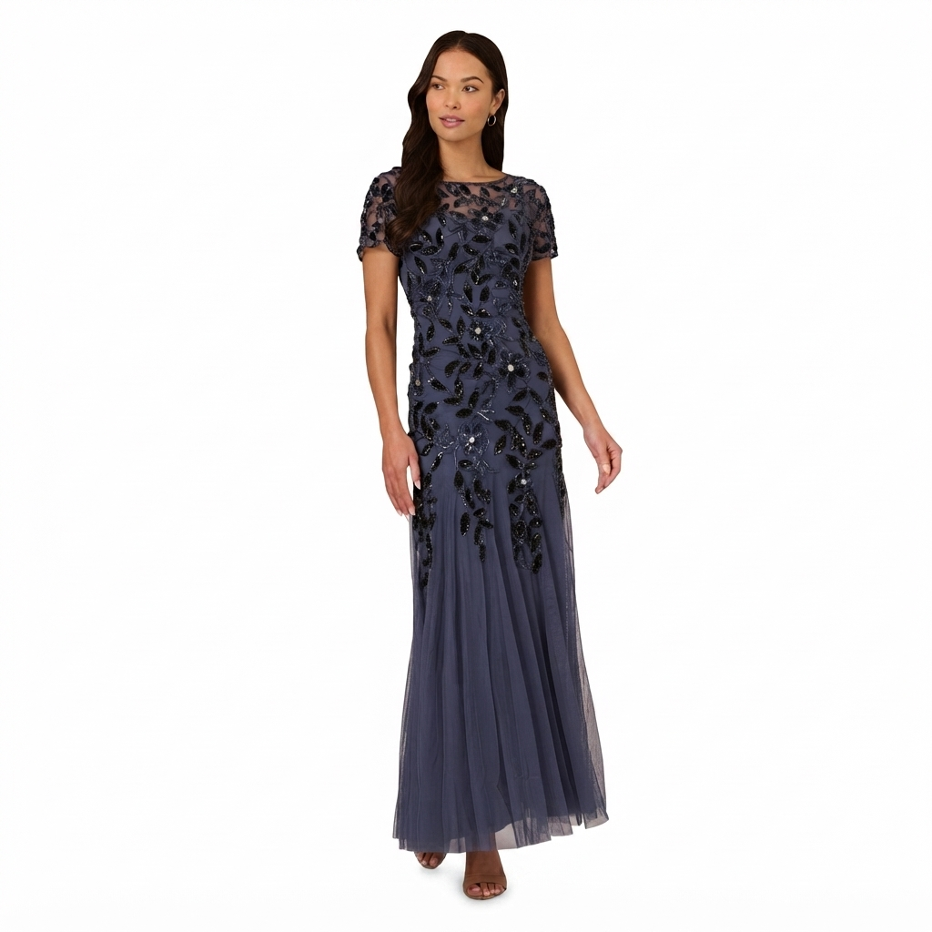 A woman modeling a floor-length navy blue evening gown with short sleeves, a sheer lace neckline, and intricate black floral beadwork and sequin embellishments on the bodice and skirt, set against a plain white background.