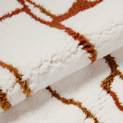 Close-up of a textured white fabric with brown geometric patterns