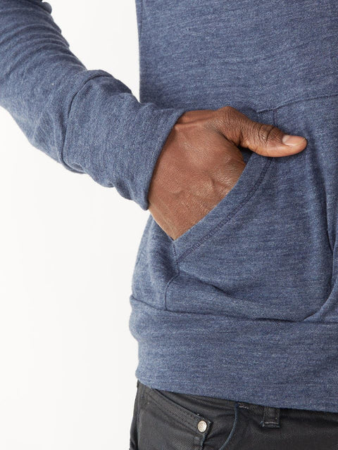 Person wearing a blue hoodie with a hand in the pocket on a white background