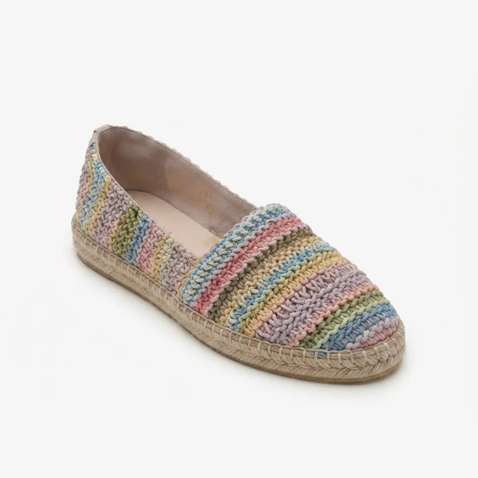 A single crochet espadrille flat shoe with horizontal stripes of pink, blue, green, yellow, and orange yarn, featuring a natural jute-wrapped sole, shown on a light gray background.