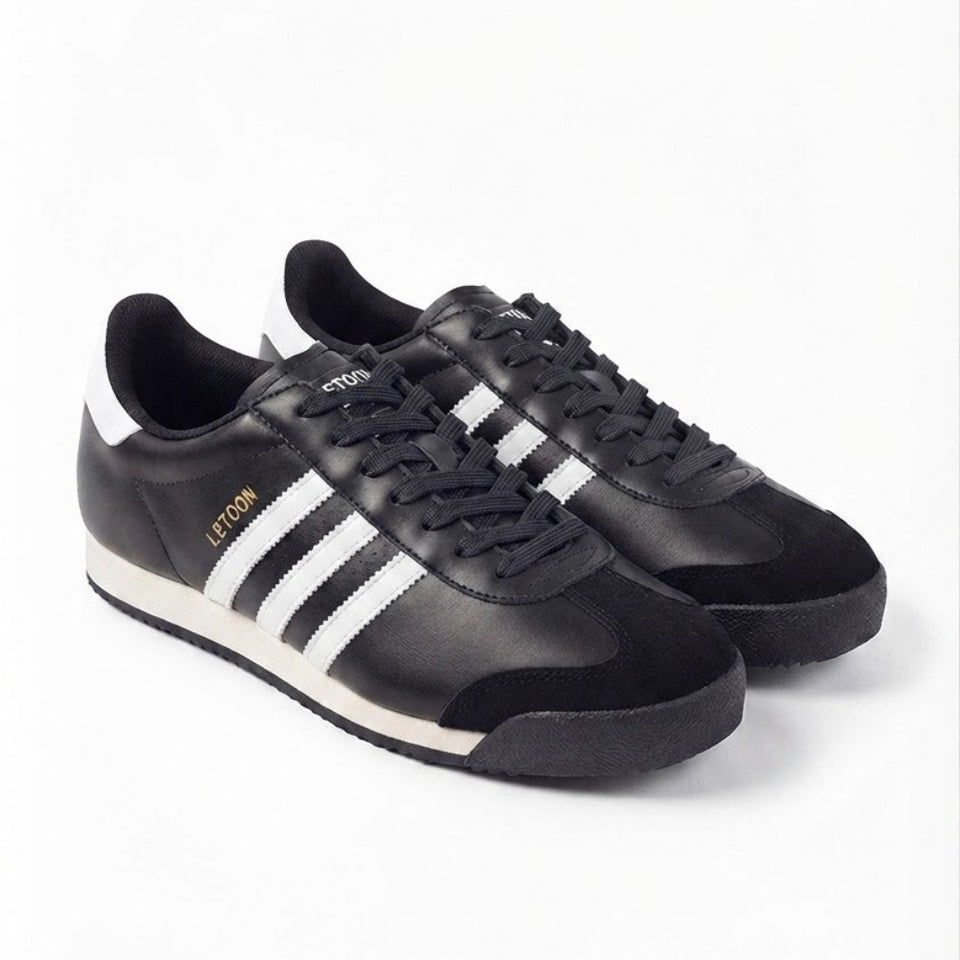 A pair of black leather Adidas Samba sneakers with white side stripes, black laces, and a white midsole, shown on a clean white background.