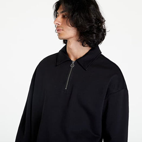 Person wearing a black quarter-zip sweatshirt on a white background