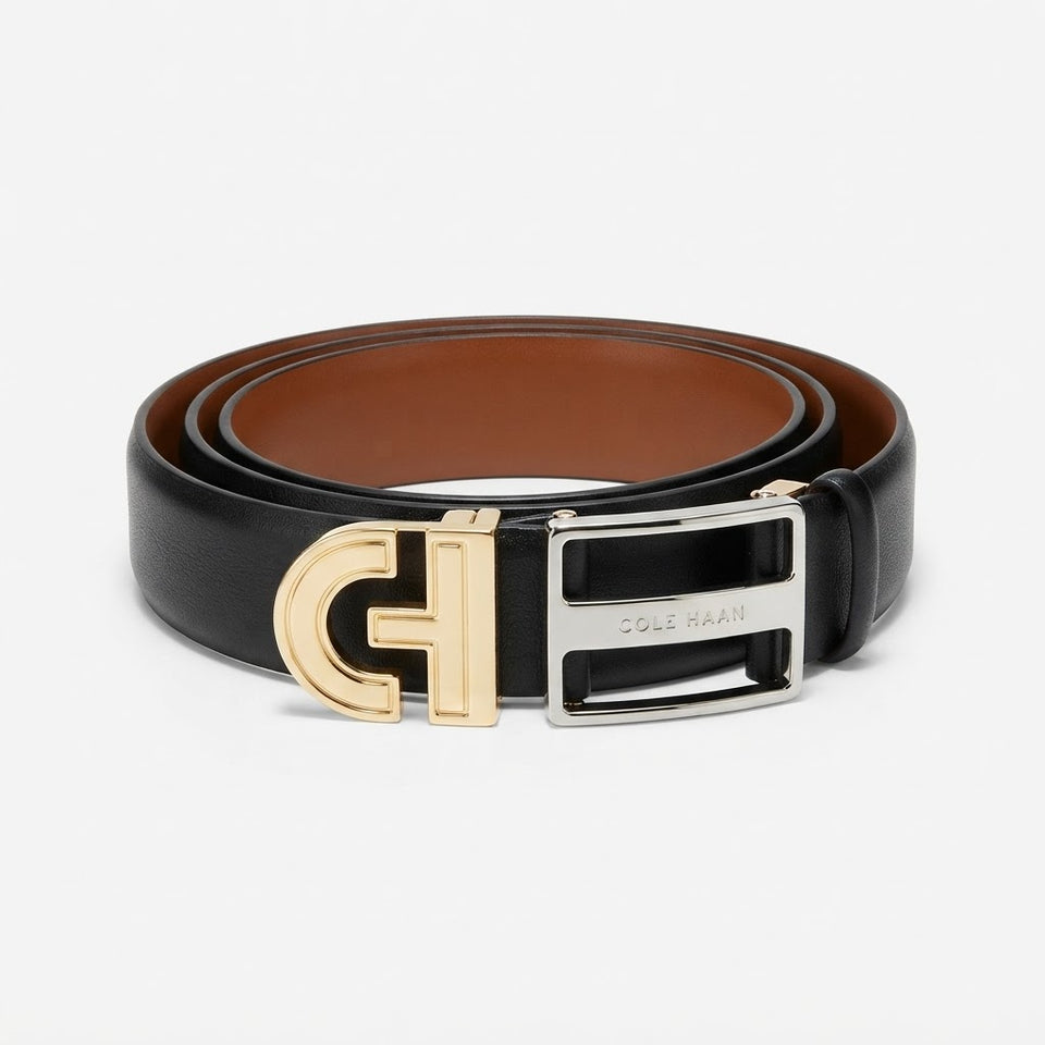 A black leather belt with a brown interior, featuring a large gold-tone 'C' buckle and a silver-tone rectangular buckle engraved with 'COLE RAAN'.
