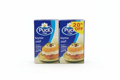Two boxes of Puck brand milk on a cardboard surface with visible branding.