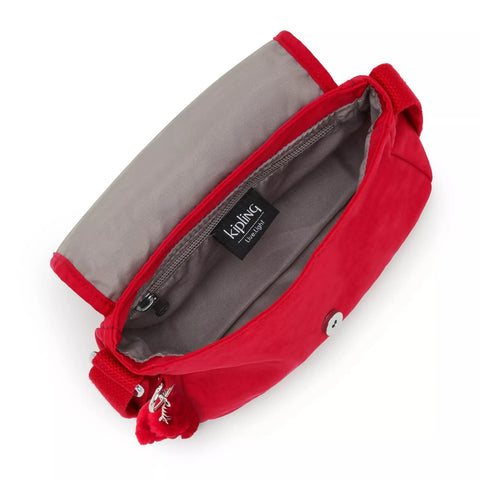 Red bag with gray interior and Kipling brand label on a white background