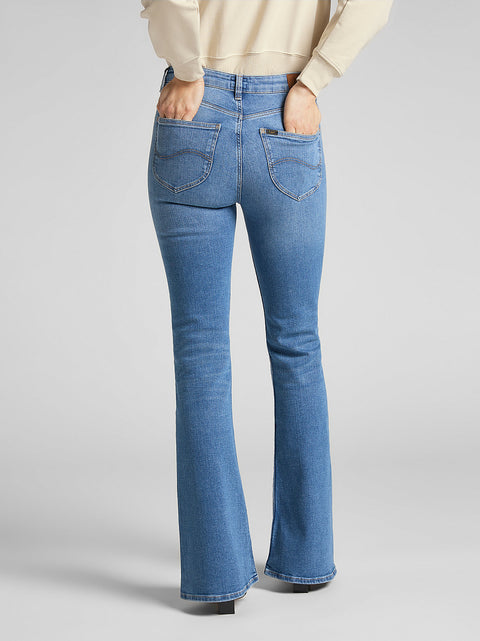 Blue flared jeans worn by a person on a light gray background