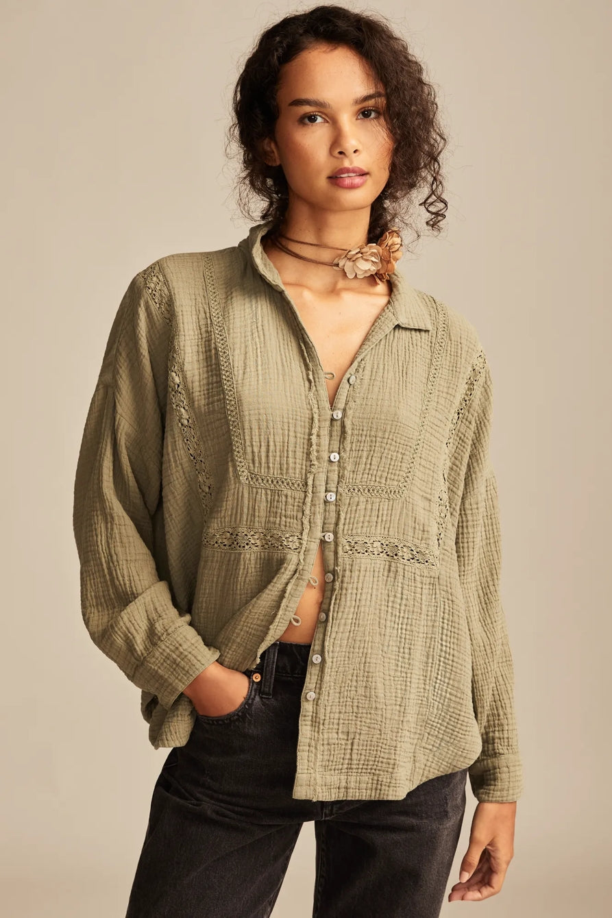 Woman wearing a green patterned shirt against a beige background