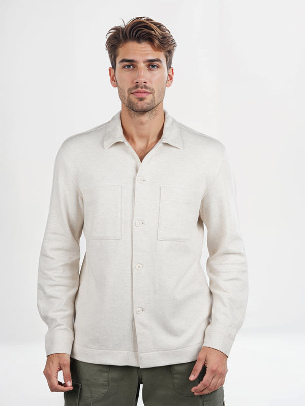 Man wearing a light-colored button-up shirt against a white background