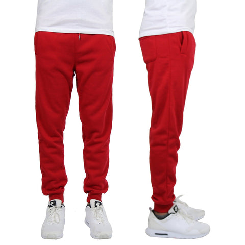 Red sweatpants worn by a person on a white background