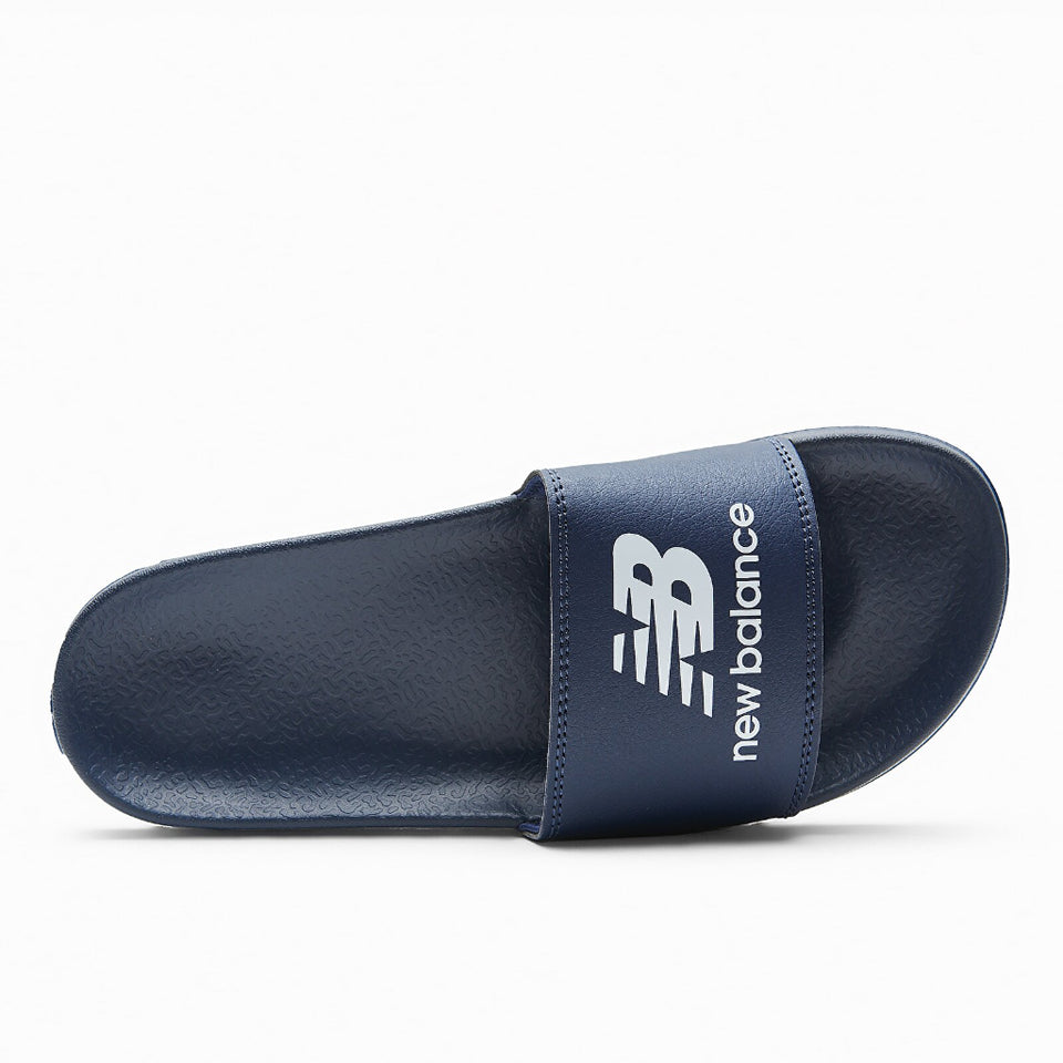 A single navy blue New Balance slide sandal shown from a side profile view against a clean white background.