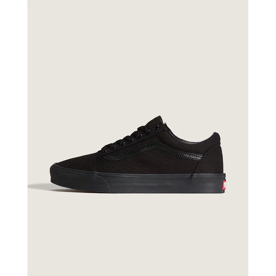 A black low-top Vans sneaker shown from the side against a light beige background.