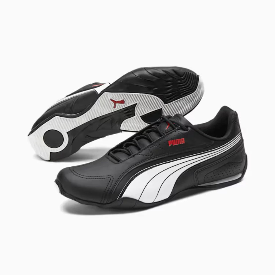 A pair of Puma sneakers in black, white, and red, with one shoe showing the side profile and the other showing the sole.