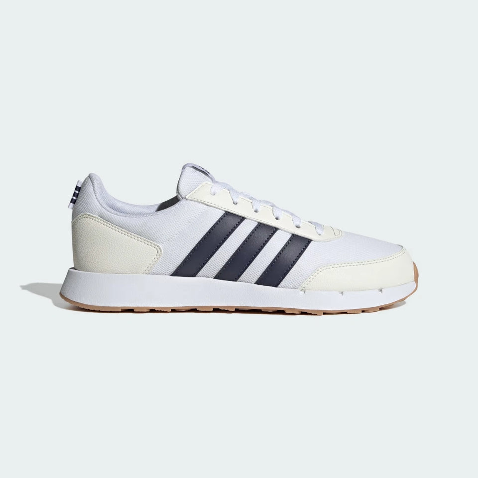 A white Adidas Korkway sneaker with three dark navy stripes, a cream midsole, and a gum brown outsole, shown from a side profile on a light gray background.