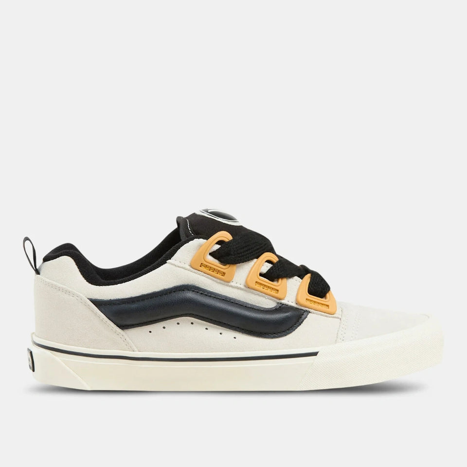 White sneaker with black and yellow accents on a white background