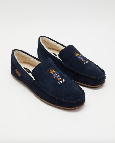 Pair of navy blue slippers with embroidered logo on a white background
