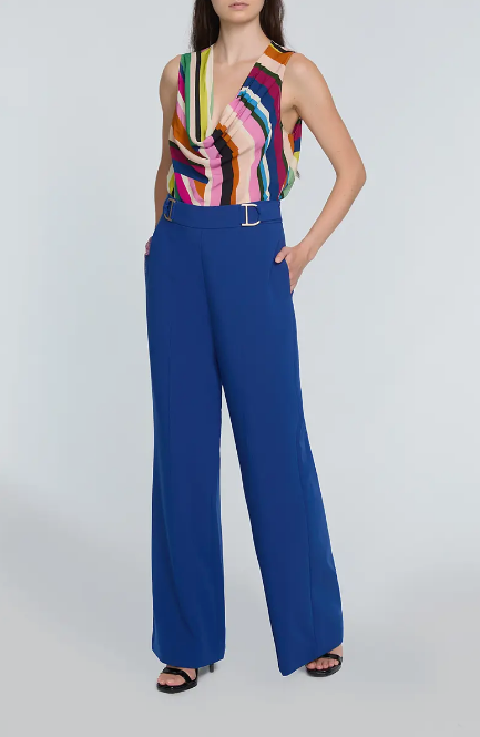 Woman wearing a colorful striped top and blue pants on a white background