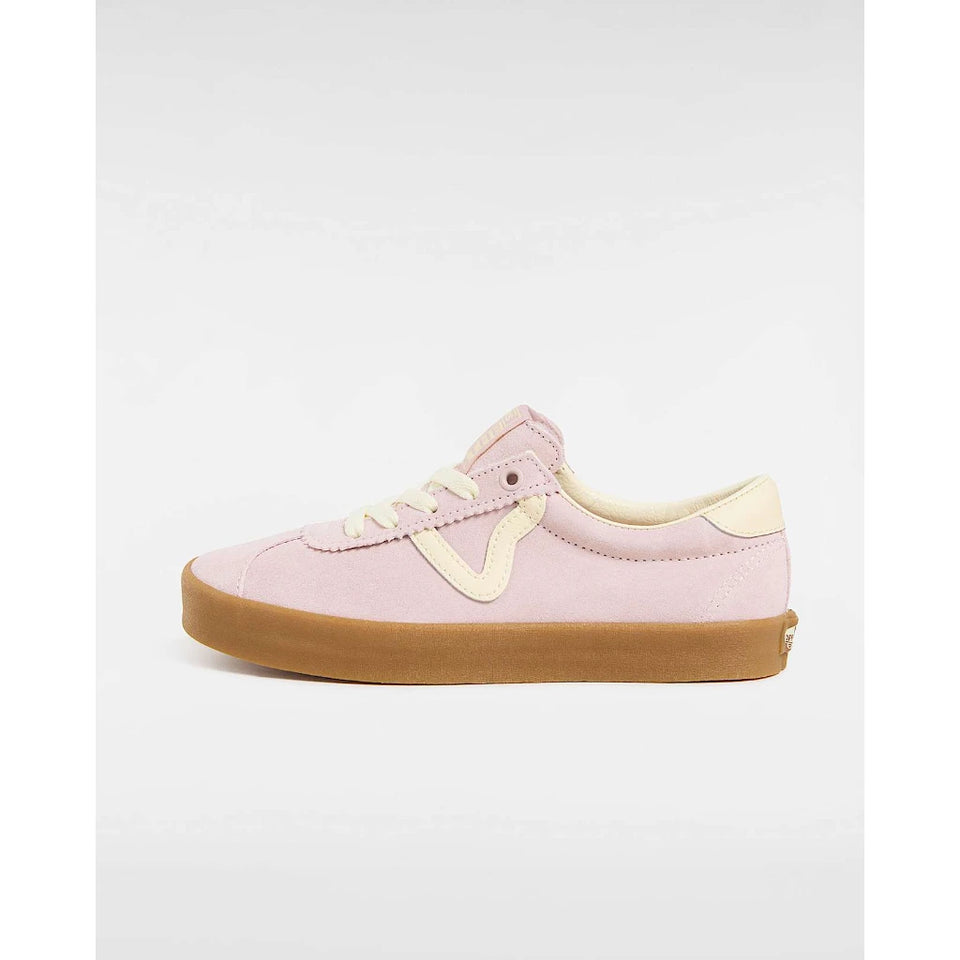 A light pink suede low-top sneaker with cream-colored laces, a cream V-shaped side accent, and a brown gum sole, shown in profile against a light gray background.