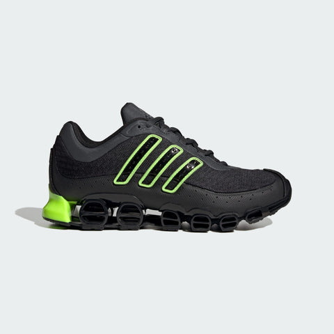 Black running shoe with green accents on a light gray background