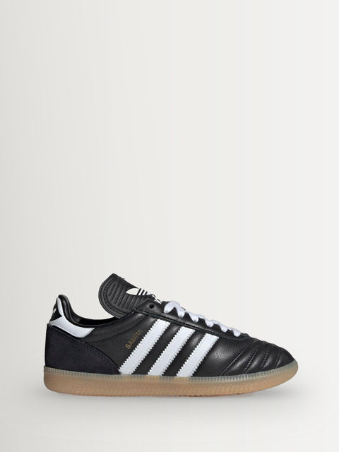 Black Adidas sneaker with white stripes on a light gray background