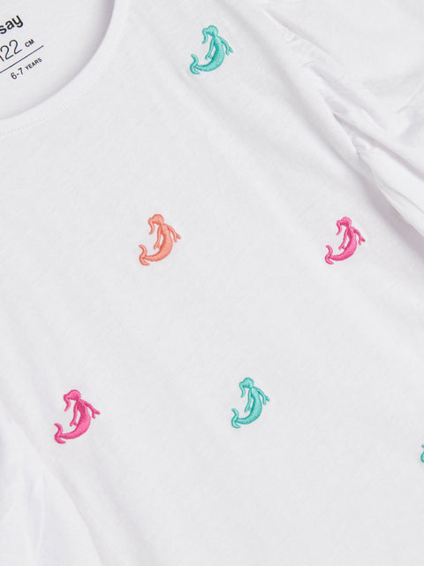 White shirt with colorful embroidered designs on a white background