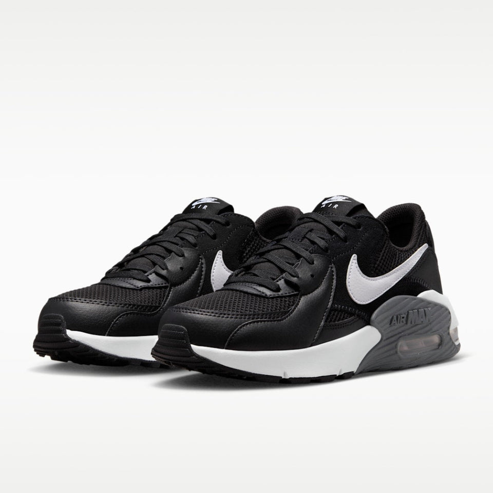 A pair of Nike Air Max sneakers in black and white, featuring a black mesh and leather upper with a prominent white Swoosh and white midsole.