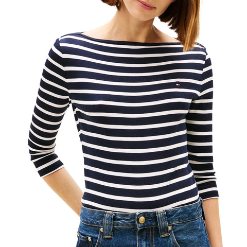 Woman wearing a navy and white striped long-sleeve shirt with a brand logo.