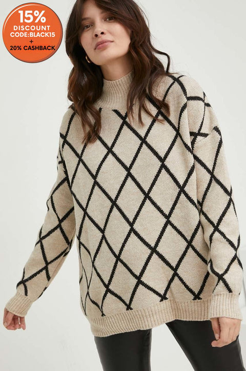 Woman wearing a beige sweater with black geometric pattern on a white background