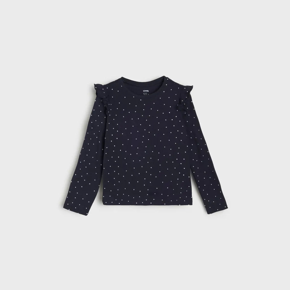 A dark navy long-sleeve top for toddlers, featuring a white polka dot pattern and ruffled shoulder details, displayed flat against a light gray background.