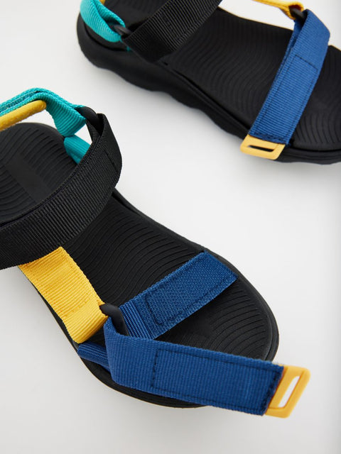 Black sandals with colorful straps on a white background
