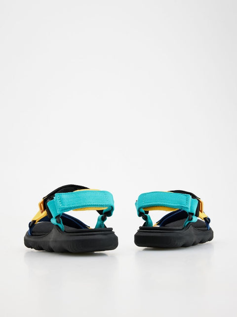 Pair of sandals with black, blue, and yellow straps on a white background