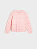 Pink sweater with red polka dots on a light gray background