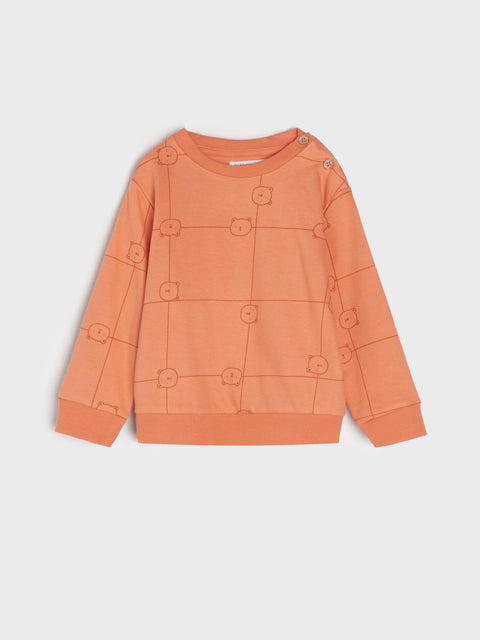 Orange sweater with button details on a light gray background