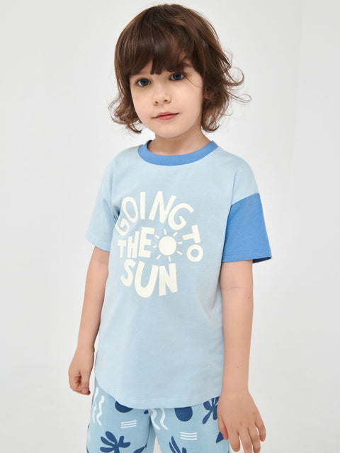 A boy wearing a blue t-shirt with the text 'Gonna be a Sun' printed on the front.