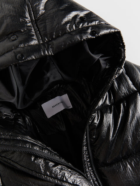 Close-up of a black quilted jacket with a brand label visible.