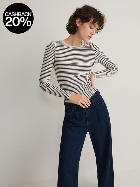 Woman wearing a striped shirt and jeans with a cashback 20% badge on a light background