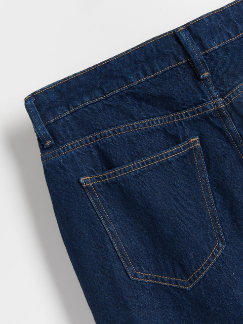 Close-up of a blue denim pocket on a plain background
