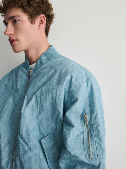 Man wearing a light blue jacket against a plain background