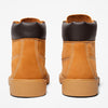 Pair of tan leather boots with black soles on a white background